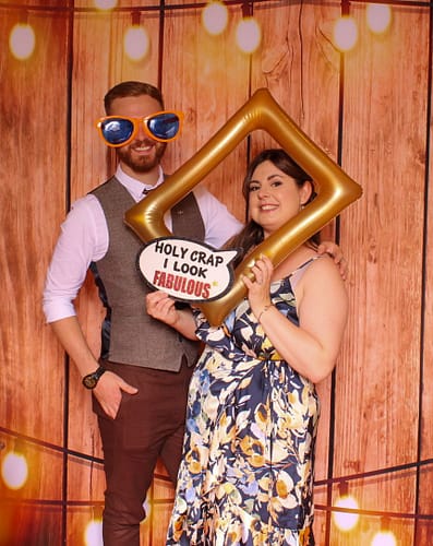 Elegant wedding guests posing with high-end props in a magic mirror photo booth at Moxhull Hall, Sutton Coldfield.