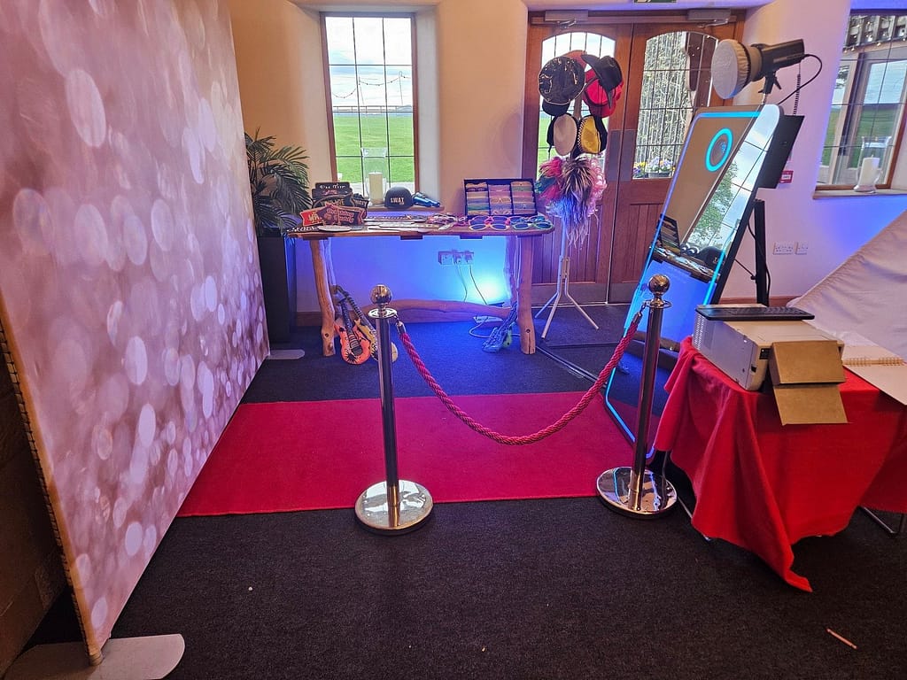Modern Magic Mirror photo booth setup with red carpet and gold bollards at a West Midlands wedding venue.